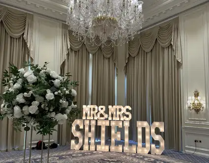Large illuminated MR and MRS BRYANT wedding letters beside a white starlit dance floor at a Scottish wedding venue