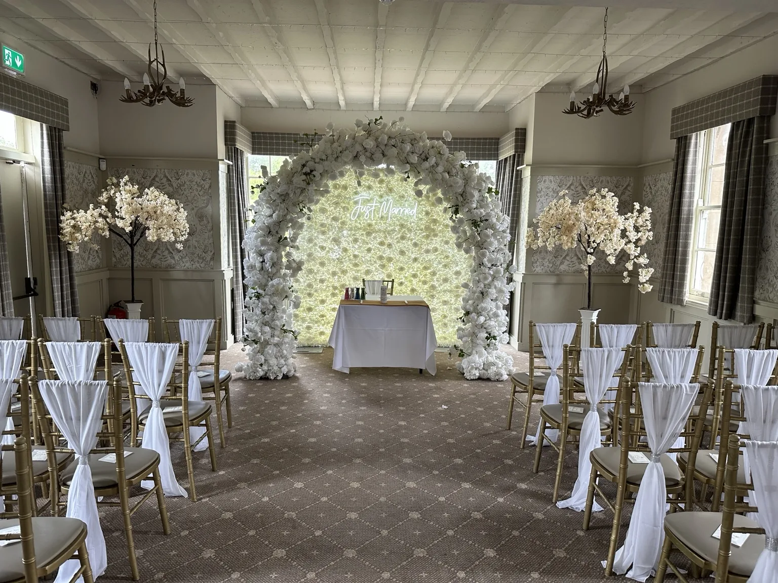 White floral arch framed by ceremony seating