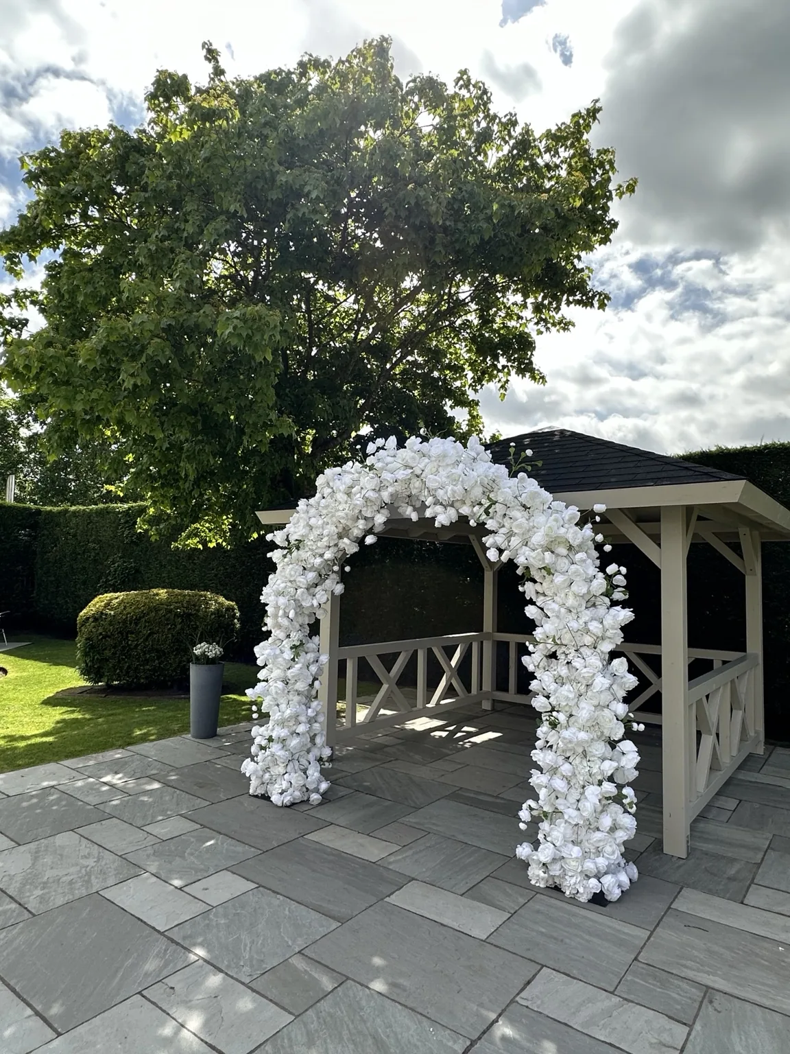 Large white floral arch installed outdoors