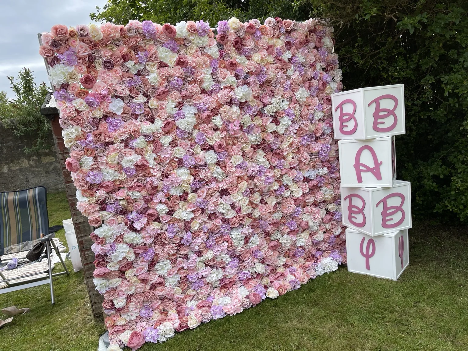 Pink flower wall installed outdoors for a celebration