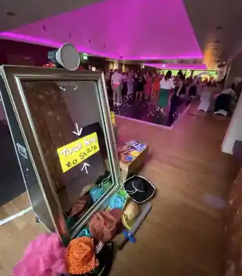 Instapic Magic Mirror with props beside a busy LED dance floor at an evening event