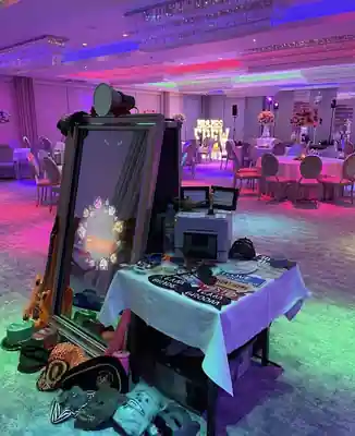 Instapic Magic Mirror with prop table and printer inside a colourful wedding reception room