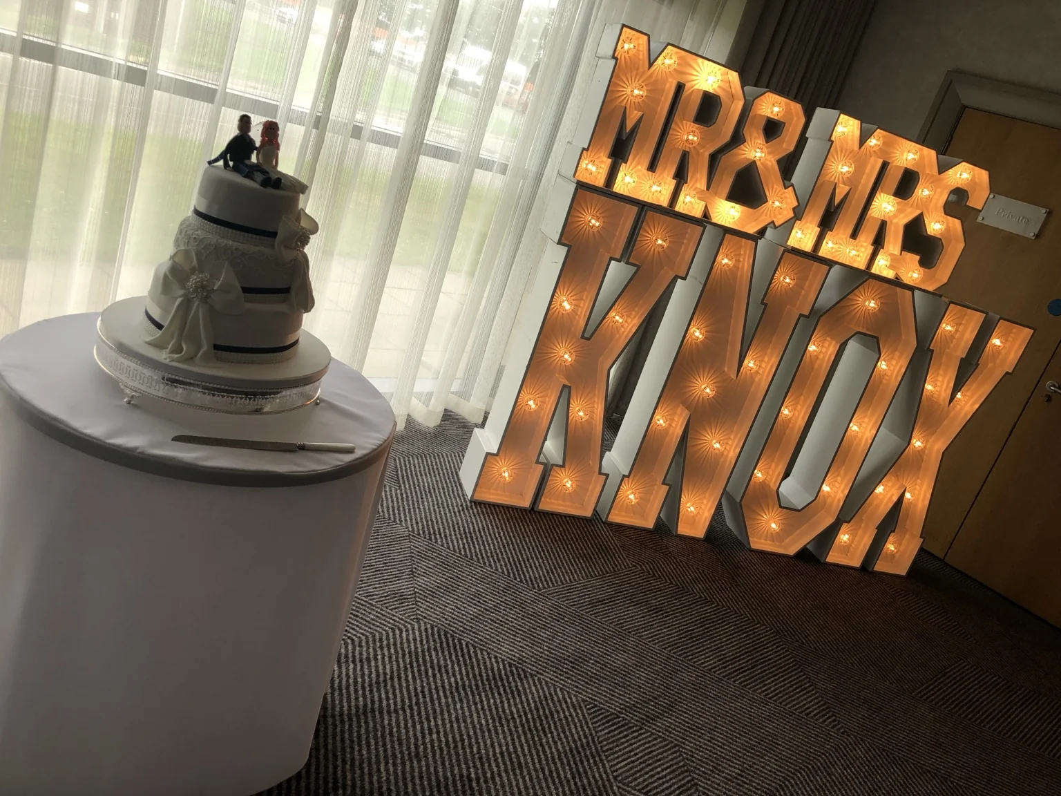 Wedding cake beside personalised KNOX light-up letters at DoubleTree by Hilton Edinburgh Airport