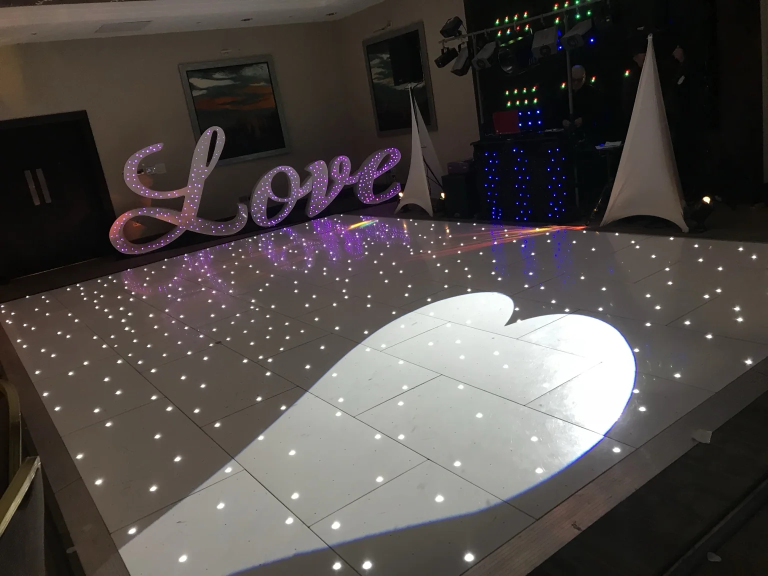 Heart-shaped light projection across a white starlit dance floor at Norton House Hotel & Spa